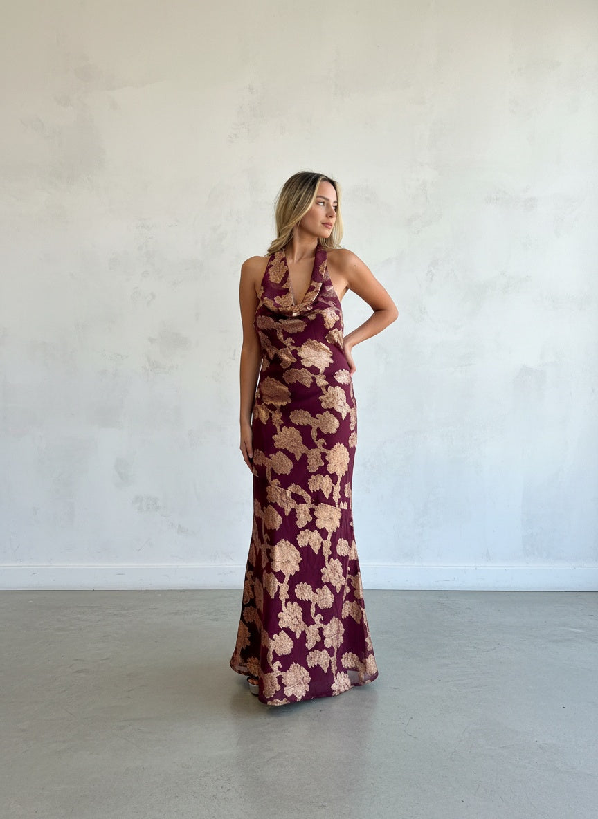 Vestido largo formal de fiesta en color burdeo con estampado floral dorado, escote en cascada drapeado y espalda descubierta