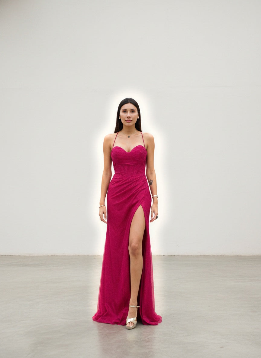 modelo con Vestido largo tipo corset en color fucsia vibrante con detalles de brillos y espalda ajustable para un calce perfecto