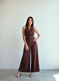 Modelo con enterito de fiesta café chocolate, con cuello halter drapeado y pantalón ancho de caída fluida