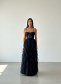 Modelo con vestido de gala negro, top tipo corset de encaje con transparencias y falda de tul con gran volumen