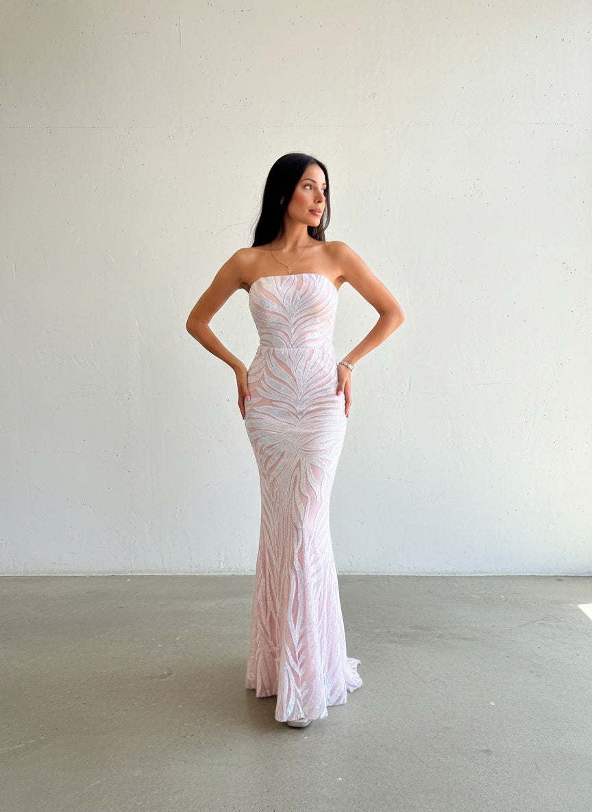 Modelo con vestido largo strapless de lentejuelas blanco con rosa, diseño corte sirena y patrón de bordado orgánico